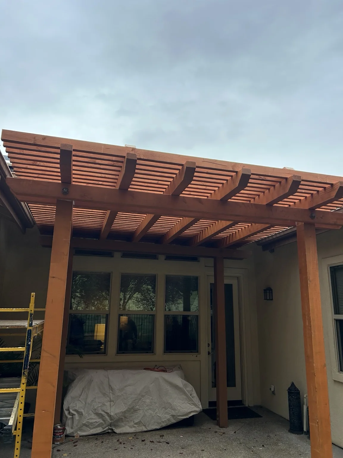 Finished custom wood pergola attached to a home
